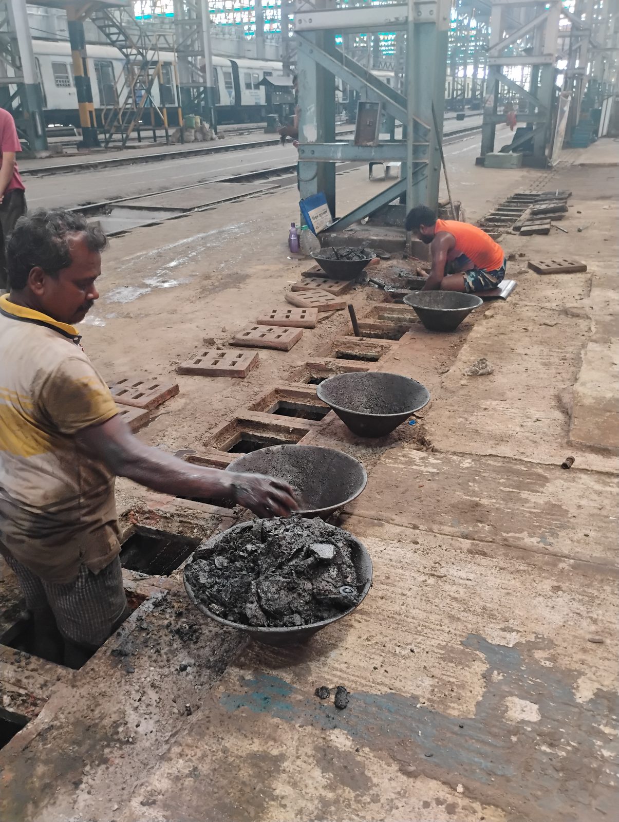 A worker clearing a blocked drainage outlet