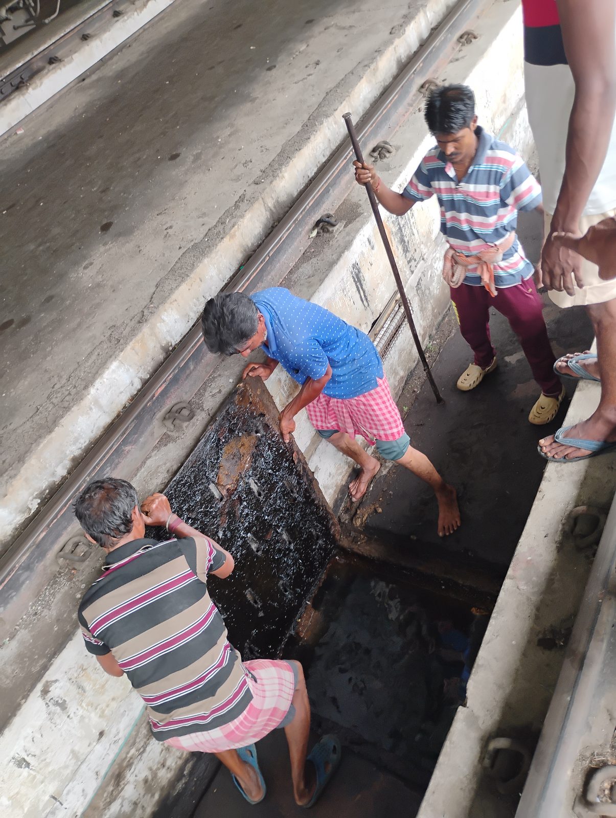 Cleaning crew working underneath a railway carriage