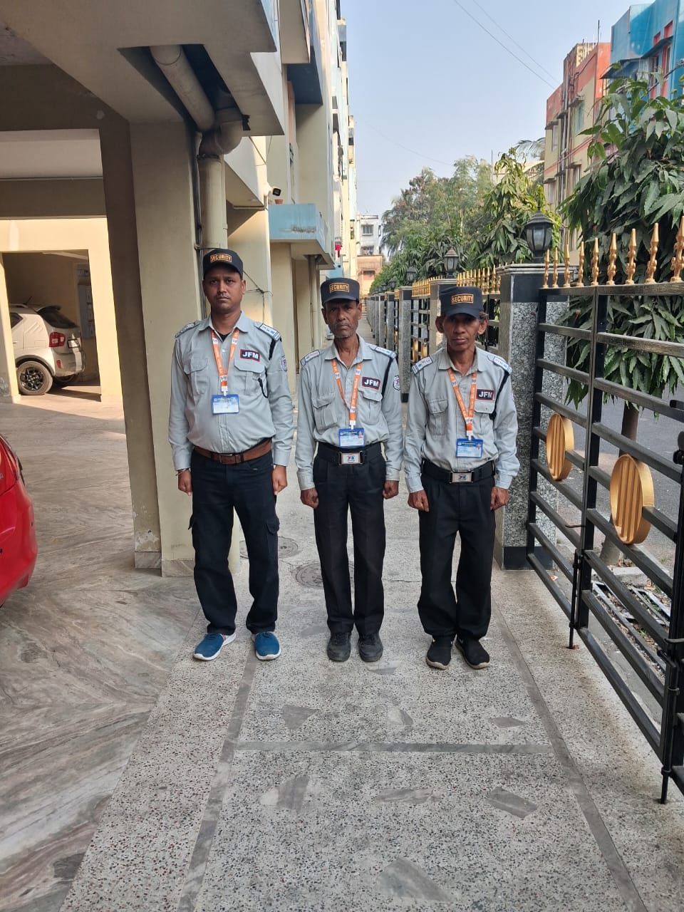 Three uniformed guards on shift at a residential gate